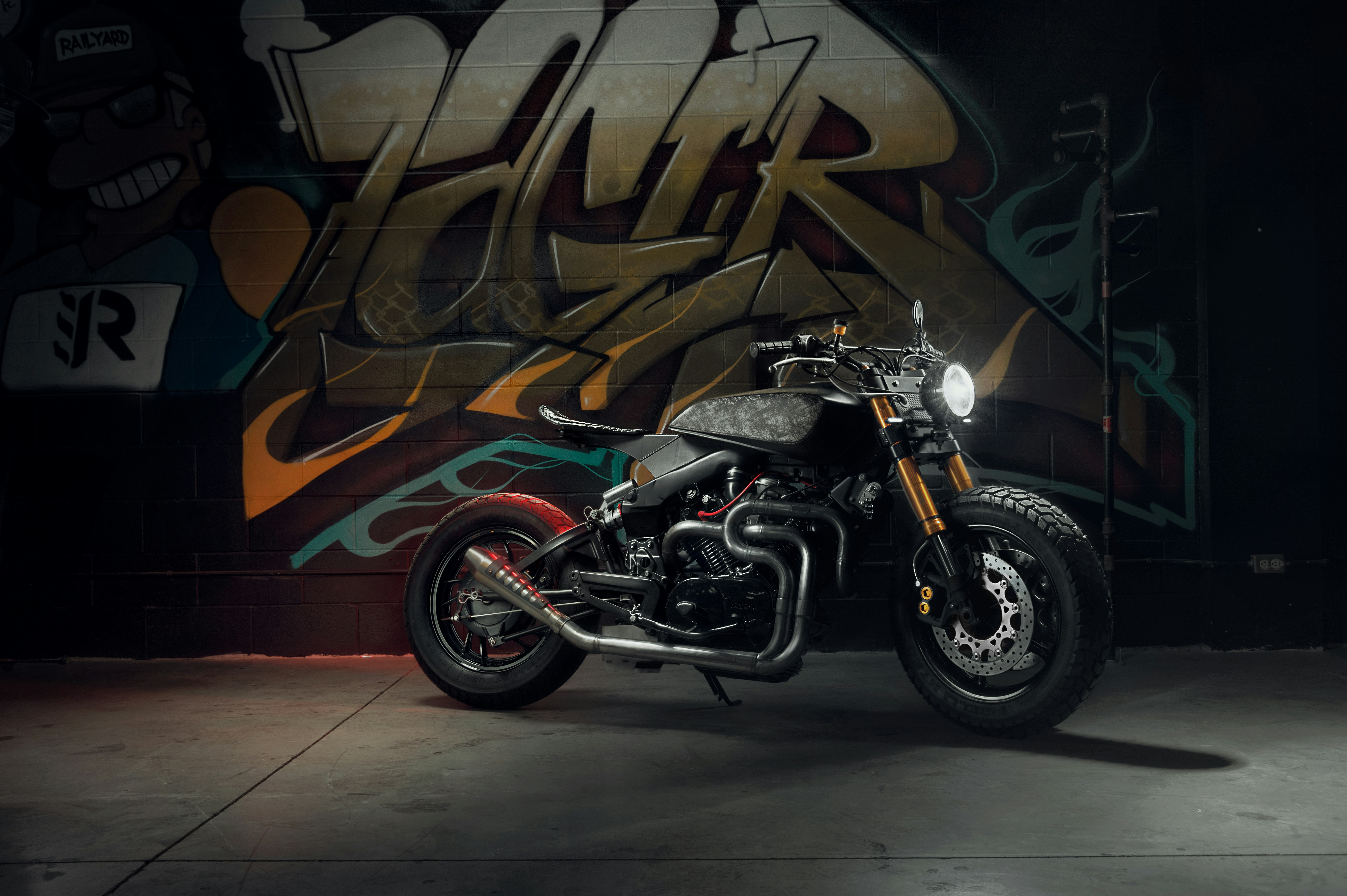 black and red motorcycle parked beside wall